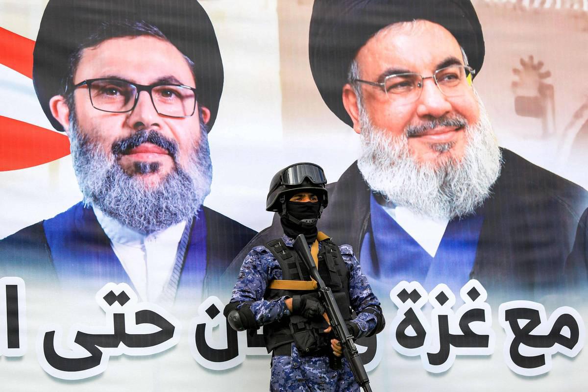 مقاتل حوثي أمام جدارية لحسن نصرالله وهاشم صفي الدين في صنعاء