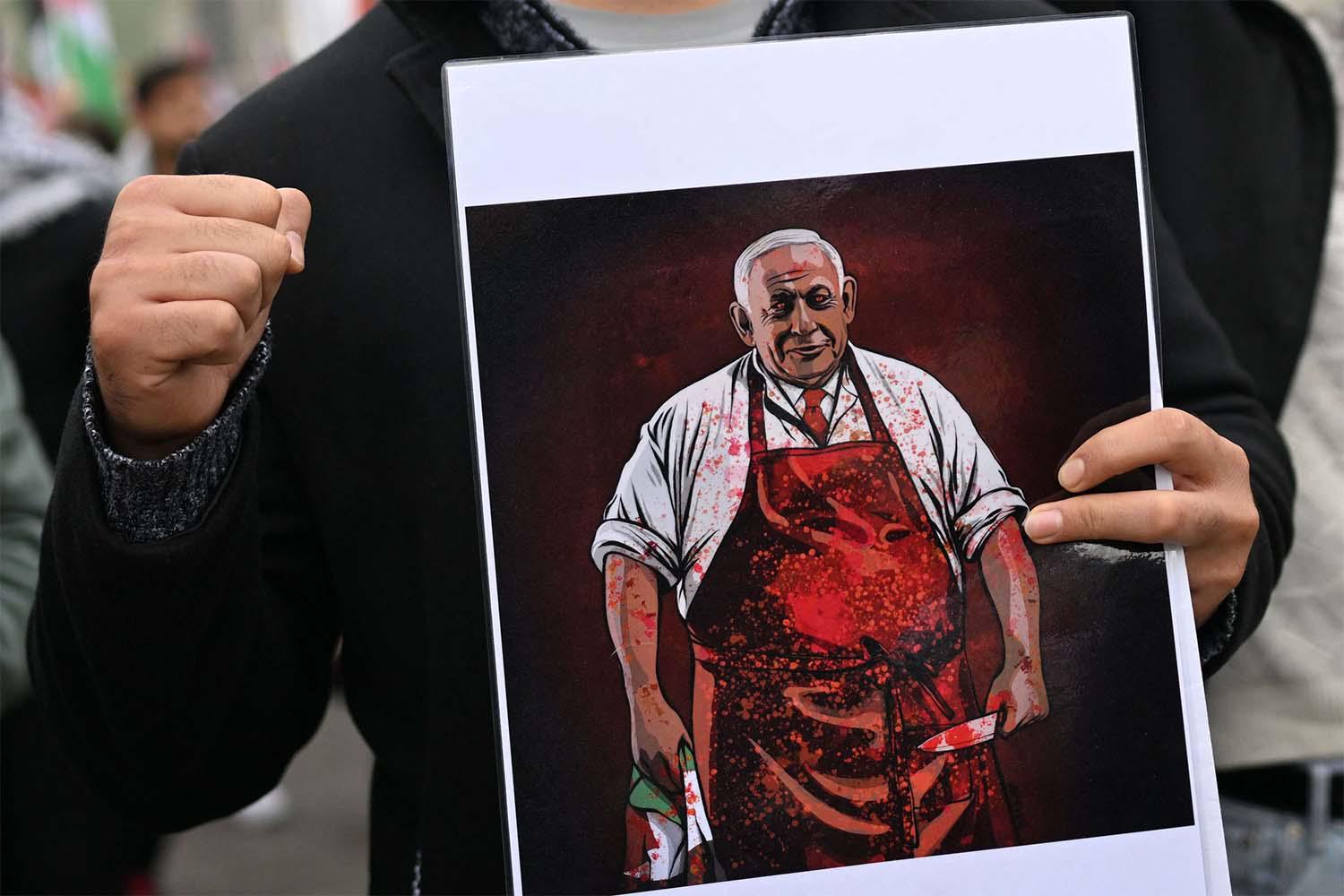 A demonstrator holds a placard depicting Israeli PM  during a Pro-Palestinian rally in Warsaw