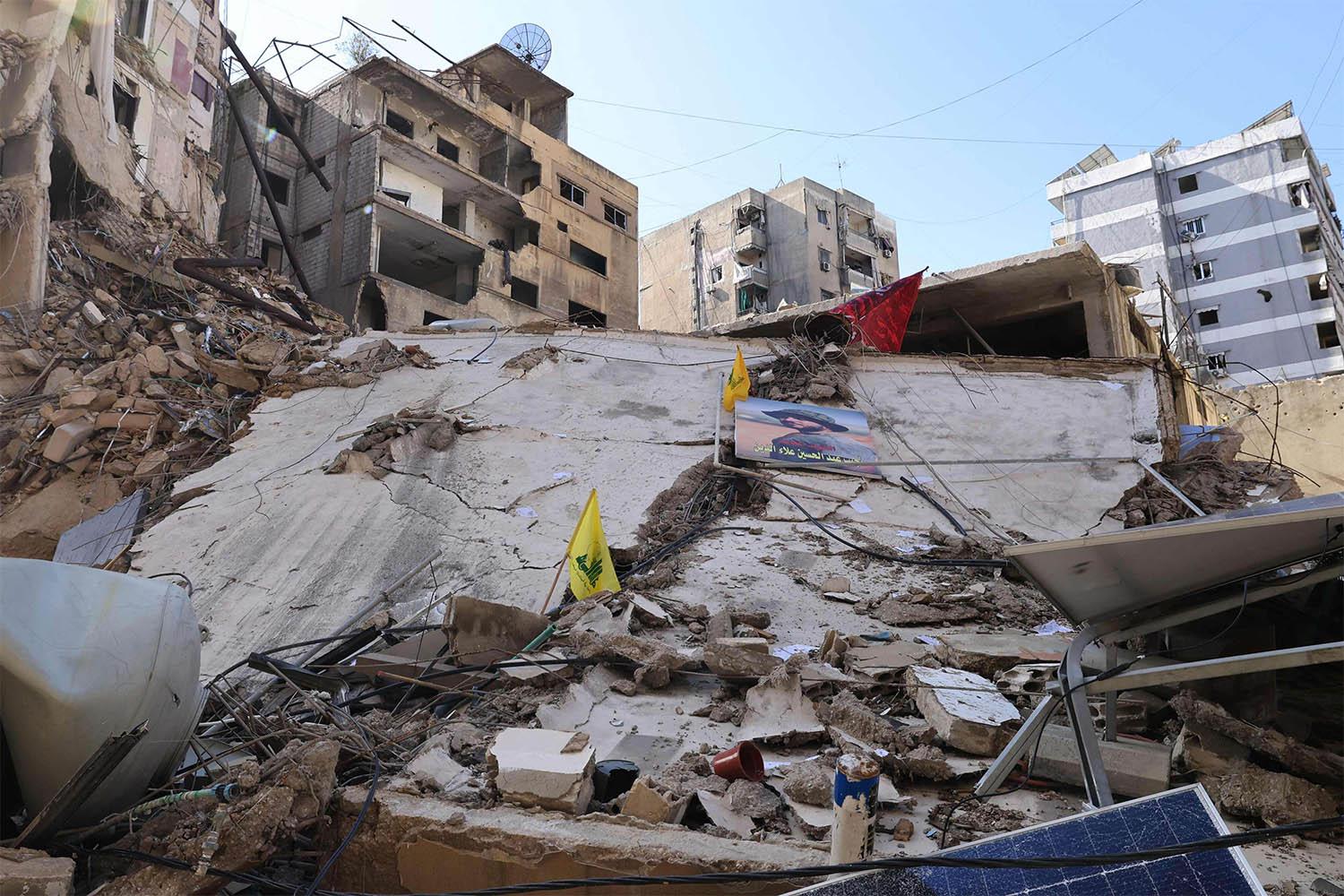 Yellow flags of Hezbollah are stuck on a building destroyed in recent Israeli bombardment in southern Beirut's Ruweiss district 