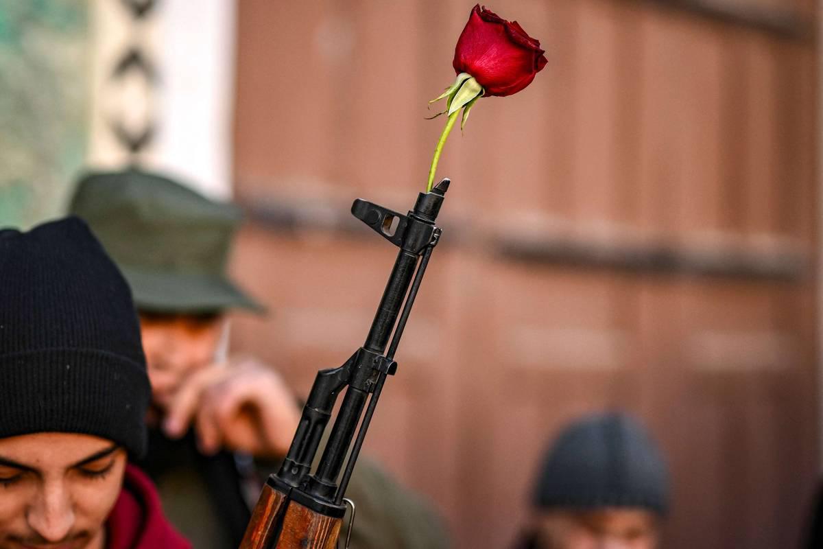 مقاتل من المعارضة السورية يضع وردة في سبطانة بندقية في دمشق