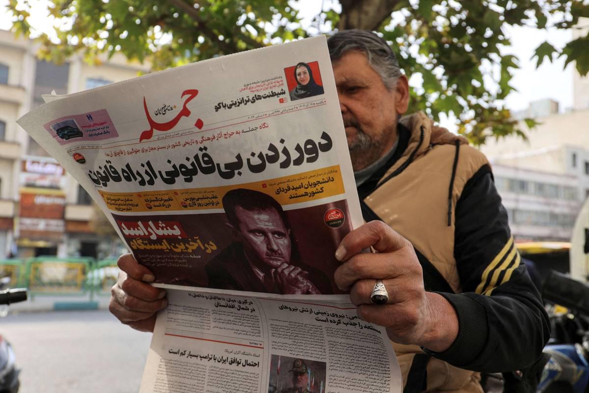 إيراني يتصفح جريدة في طهران