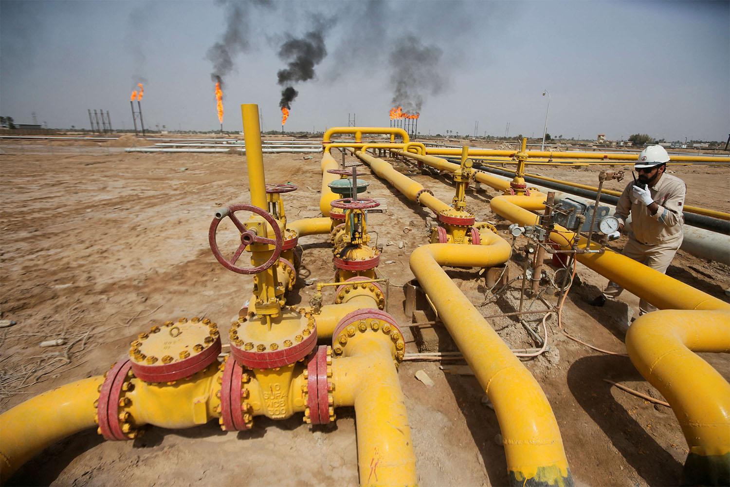A worker checks an oil pipeline at Nahr Bin Umar oil field, north of Basra