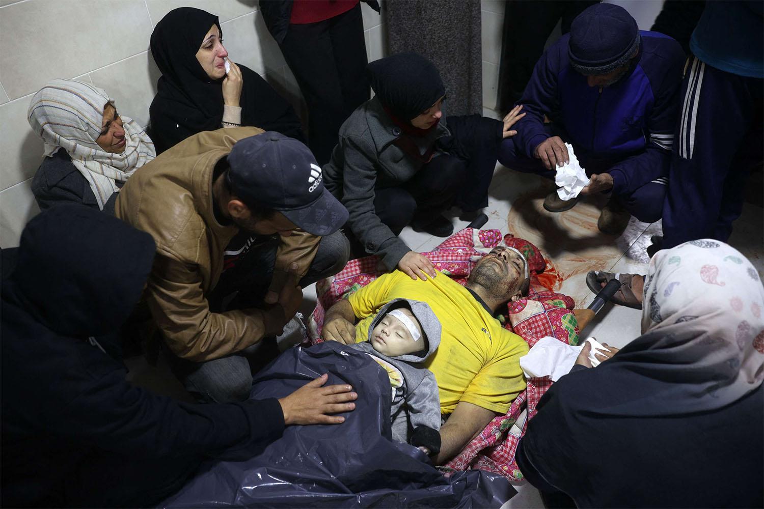 Palestinians mourn relatives killed in an Israeli airstrike in the Nuseirat refugee camp