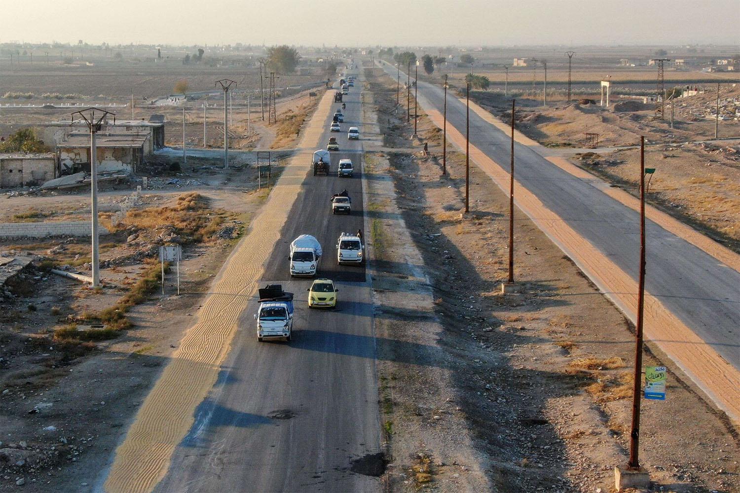 Syrian Kurds driving vehicles loaded with belongings on the Aleppo-Raqqa highway 
