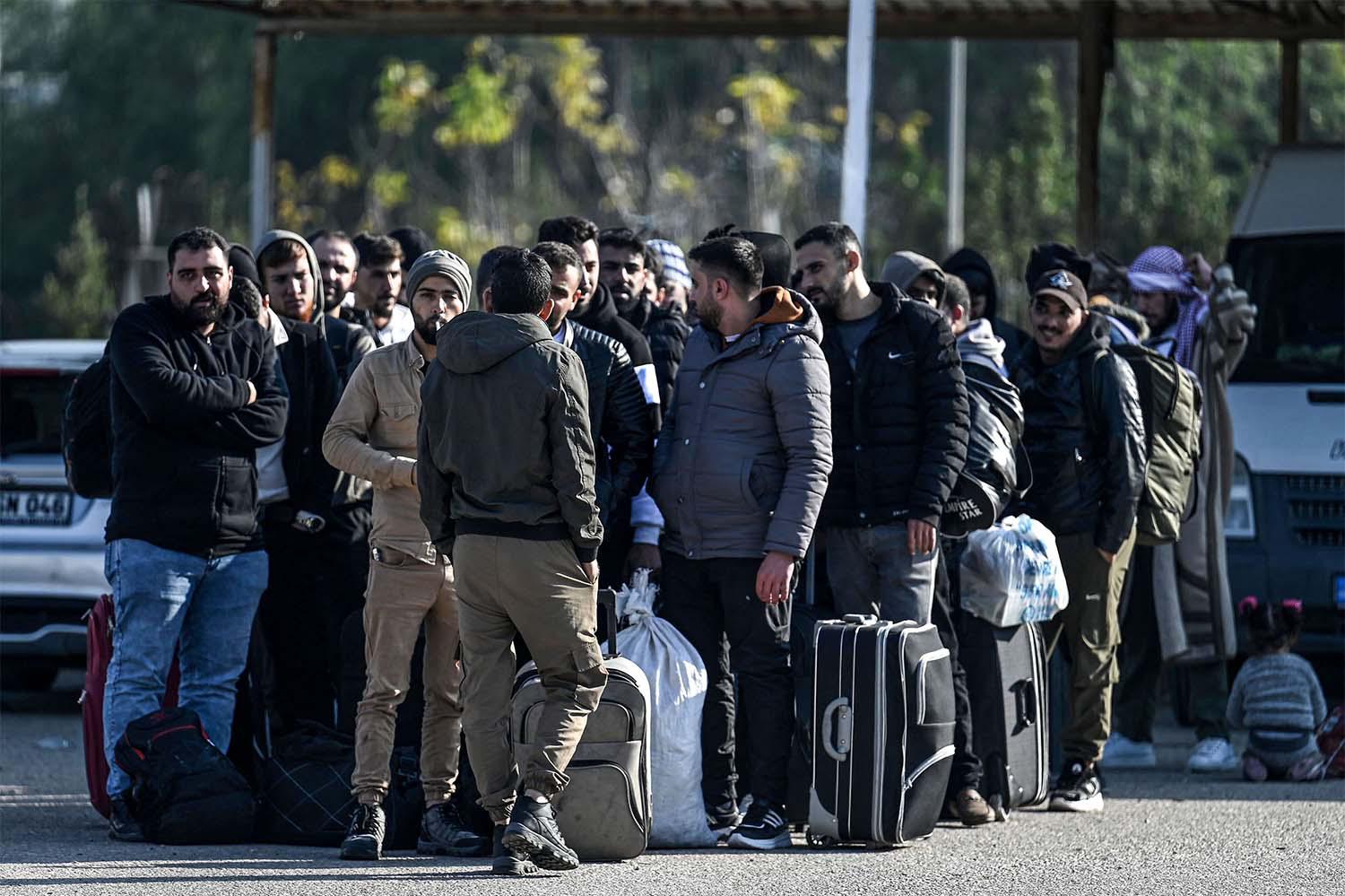 Syrian refugees who lives in Turkey wait with their belongings at Cilvegozu crossborder gate before entering in Syria