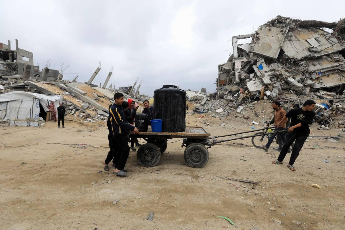 أطفال فلسطينيون ينقلون وقودا في شوارع غزة المهدمة