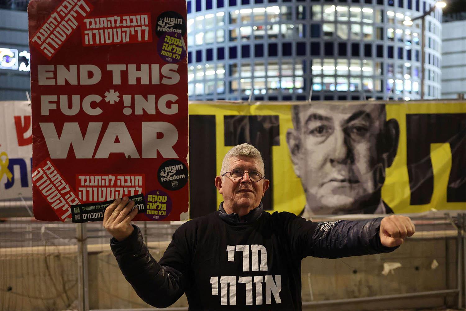 A demonstrator raises a placard during a protest calling for the release of hostages in front of the Israeli Defence Ministry in Tel Aviv 