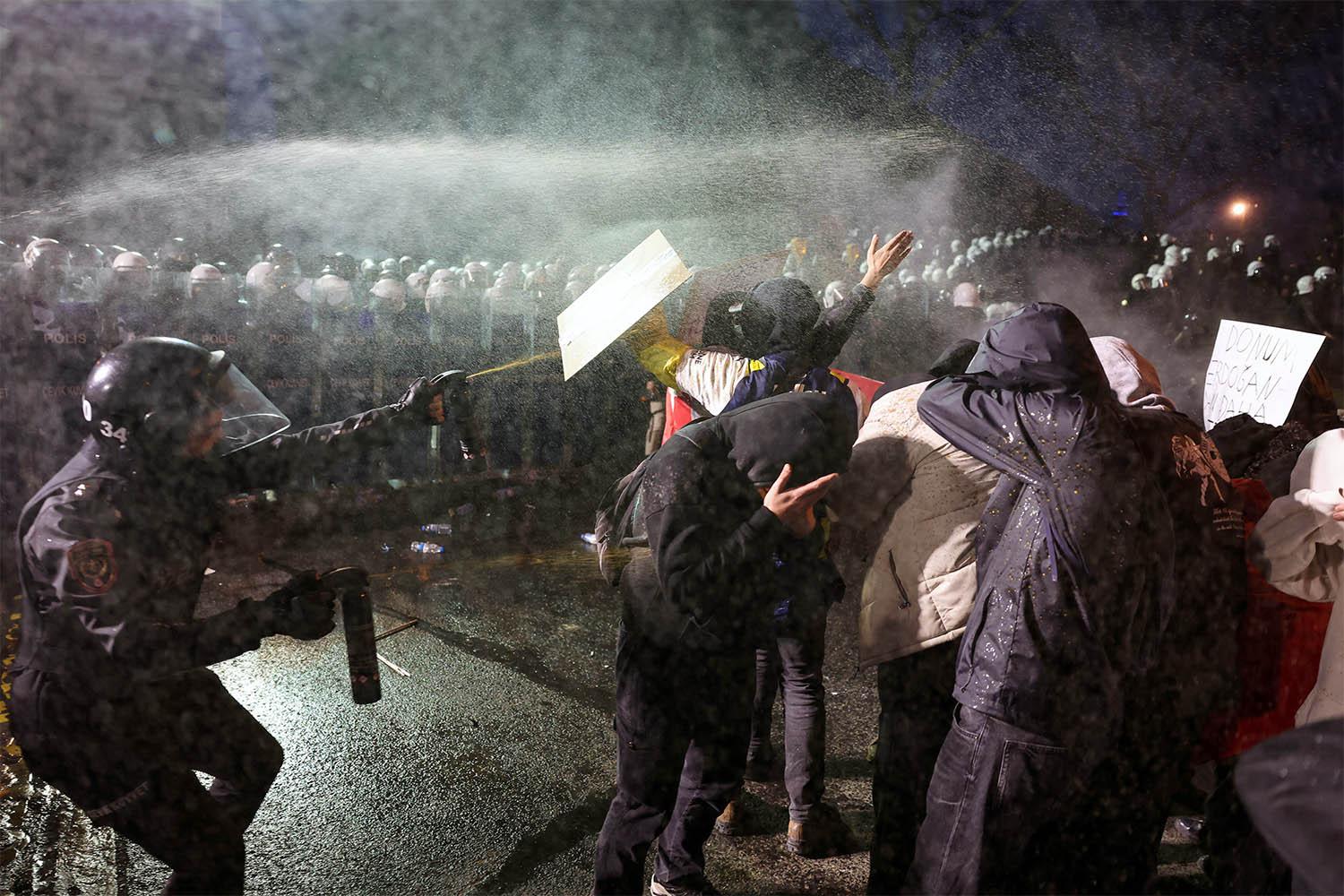 Police officers use pepper spray on demonstrators during a protest against the detention of Istanbul Mayor Ekrem Imamoglu