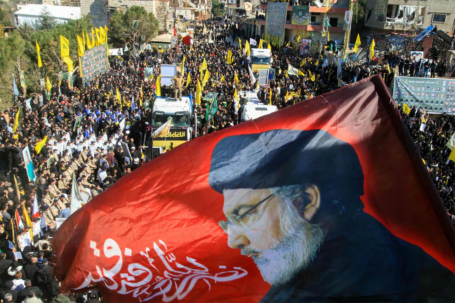 A flag bearing a portrait of slain Hezbollah leader Hassan Nasrallah waves during the funeral on February 28, 2025 of 95 Hezbollah fighters and civilians killed in Israeli airstrikes during hostilities between Israel and Hezbollah