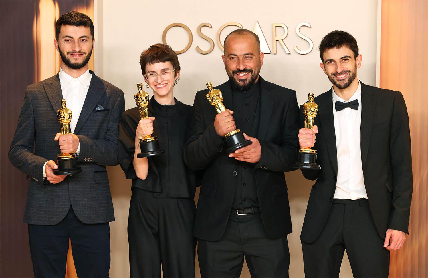 Basel Adra, Rachel Szor, Hamdan Ballal and Yuval Abraham pose with the Oscar for Best Documentary Feature Film for No Other Land 