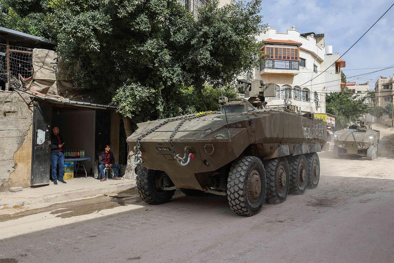 Israeli armoured vehicles drive by during a raid in the eastern neighbourhood of Jenin in the occupied West Bank