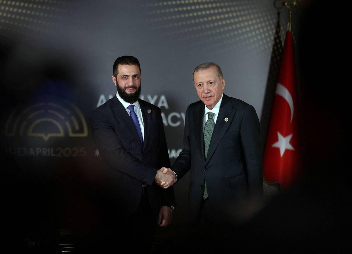 الرئيس التركي رجب طيب أردوغان يصافح الرئيس السوري أحمد الشرع