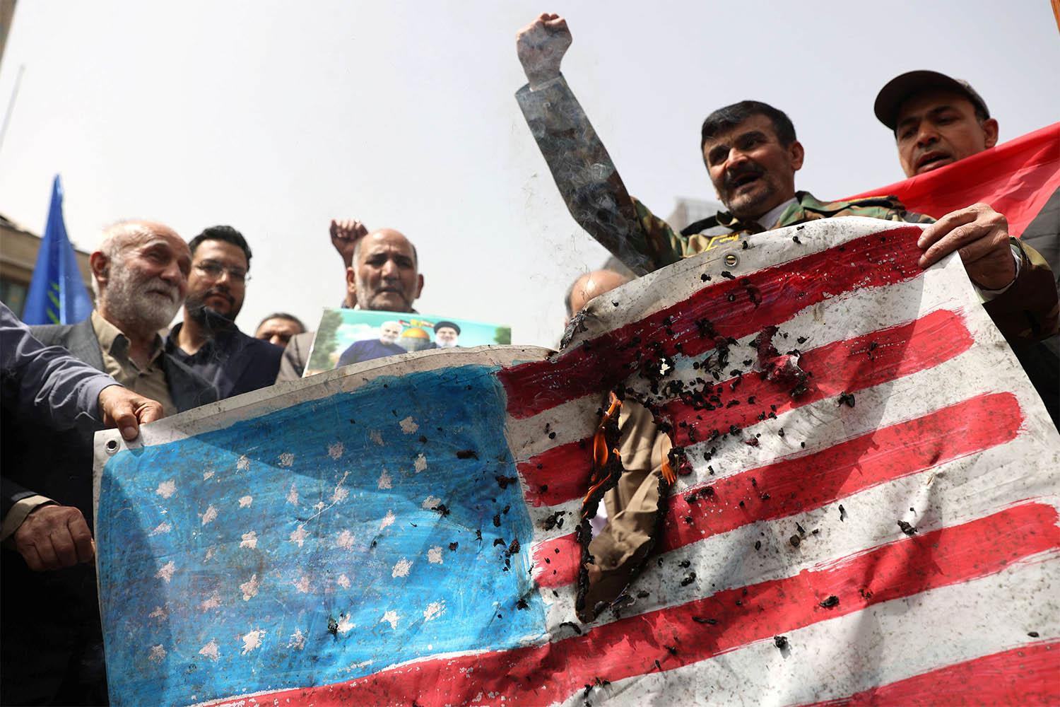 Iranians burn a US flag during a gathering in support of Gaza, in Tehran