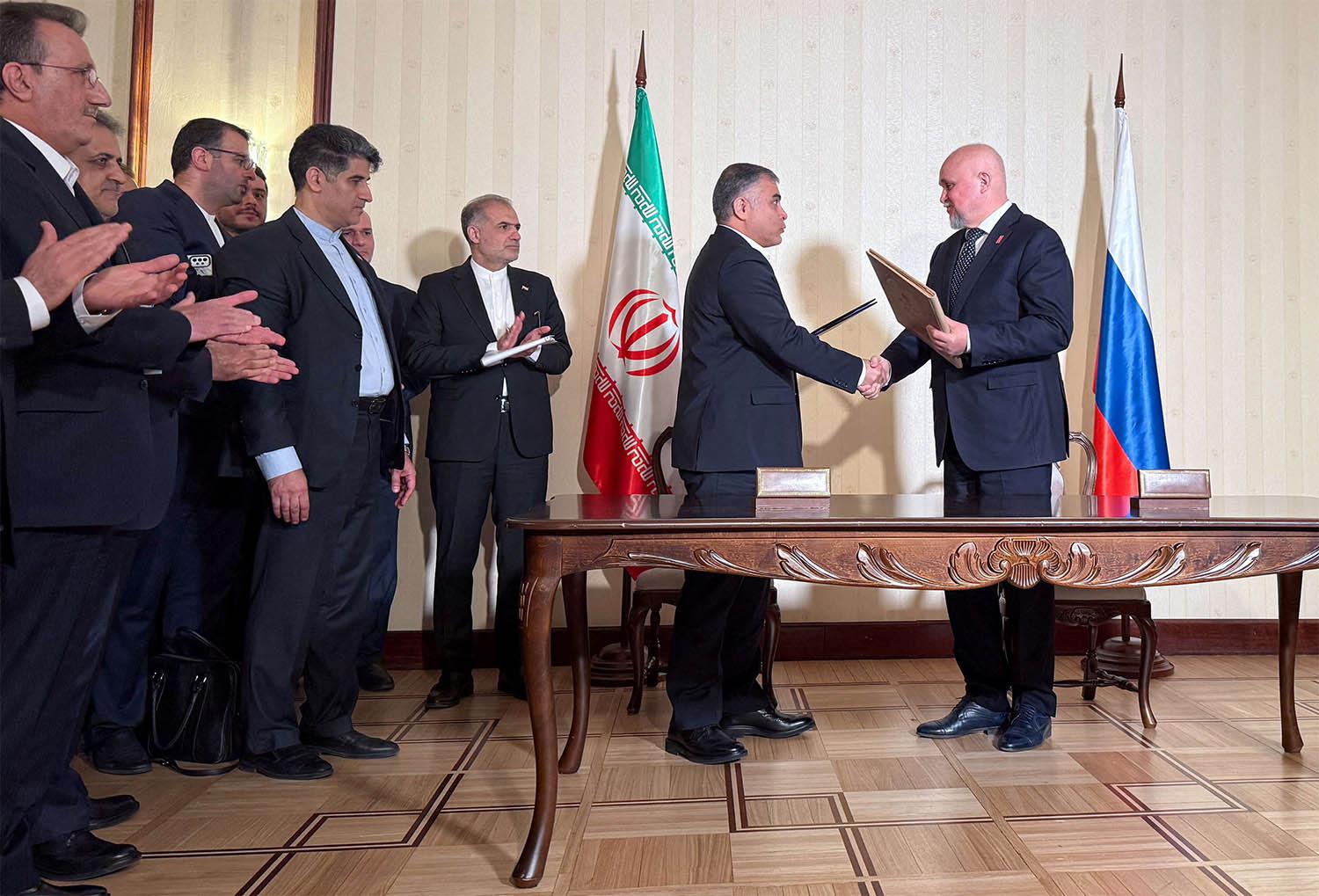 Russian Energy Minister Sergei Tsivilev and Iranian Oil Minister Mohsen Paknejad exchange documents during a signing ceremony in Moscow