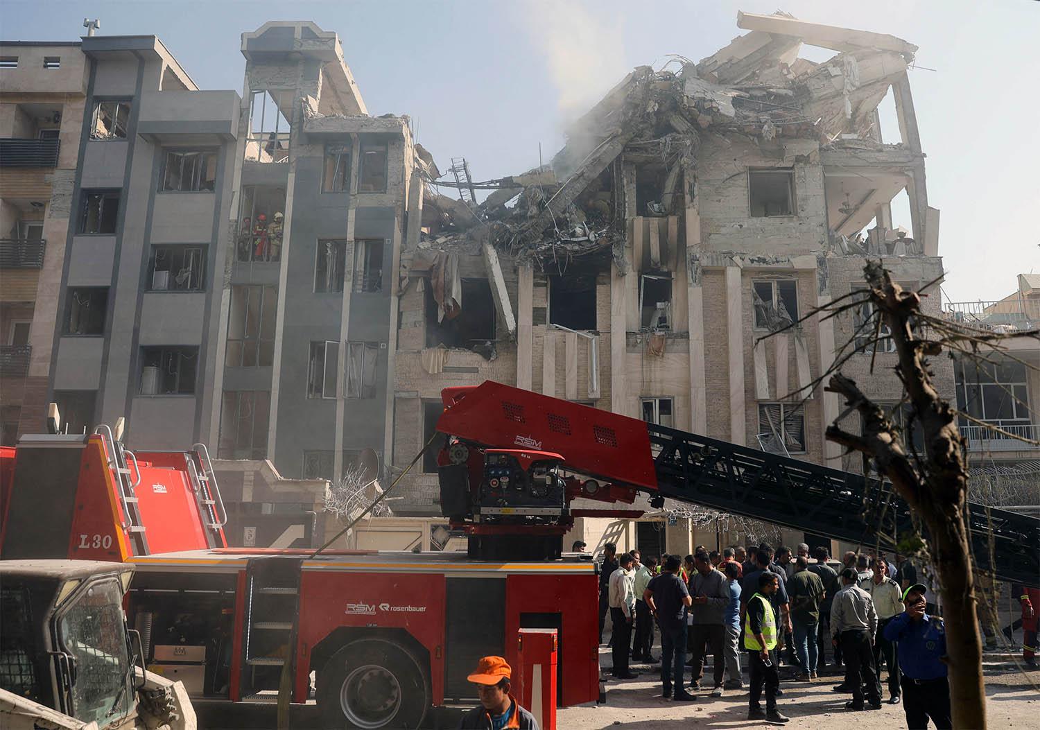 Rescuers work at the scene of a damaged building in the aftermath of Israeli strikes, in Tehran