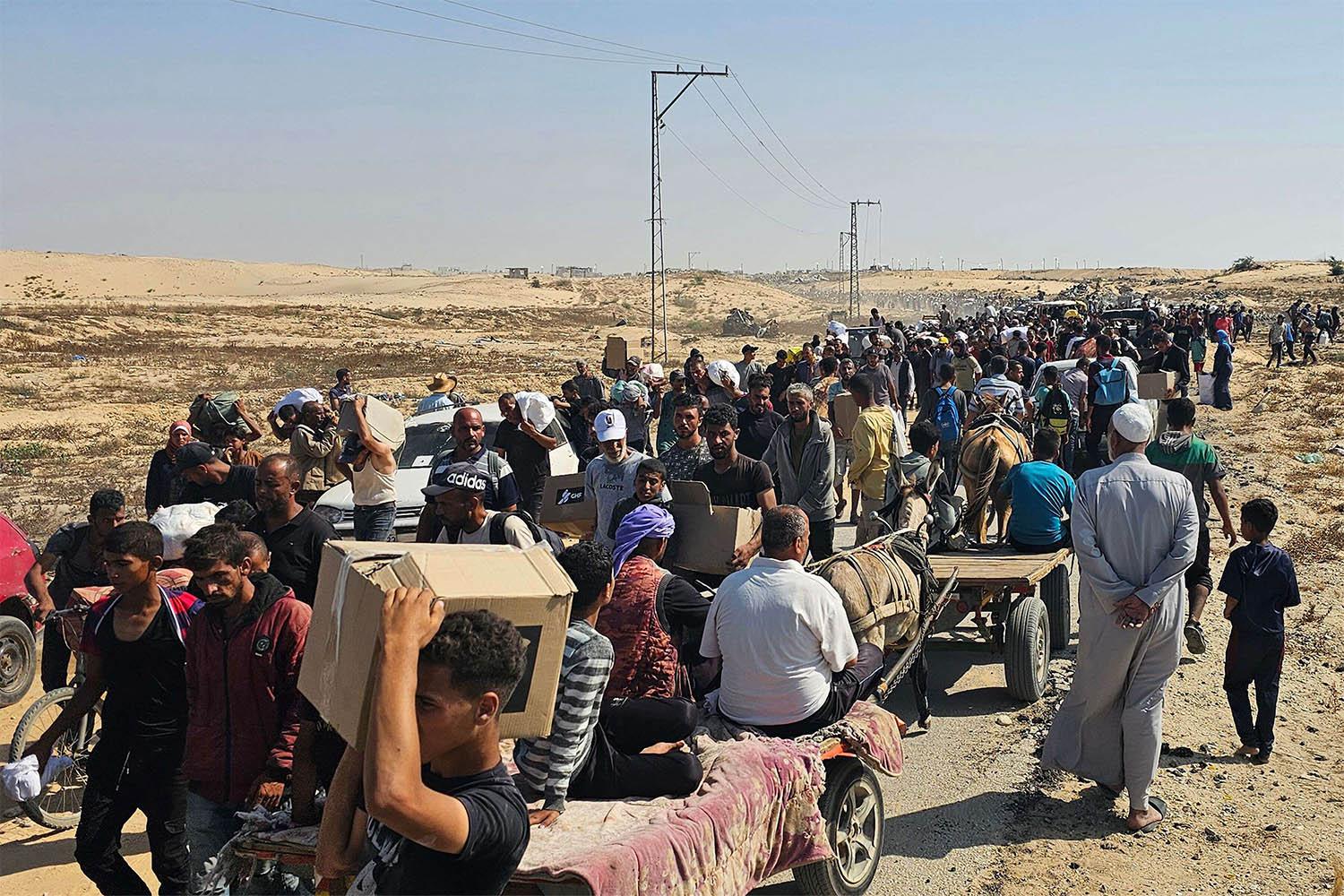 Displaced Palestinians walk along a road to receive humanitarian aid packages from a US-backed foundation in Rafah in the southern Gaza Strip on June 