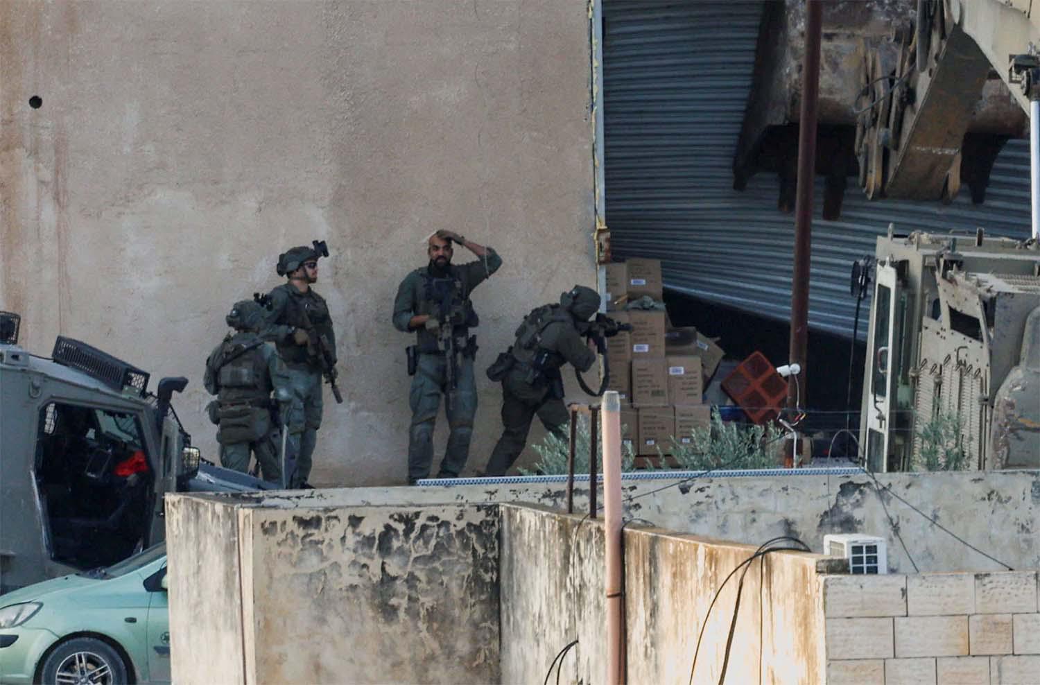 Israeli soldiers take position during a raid in Jenin in the Israeli-occupied West Bank