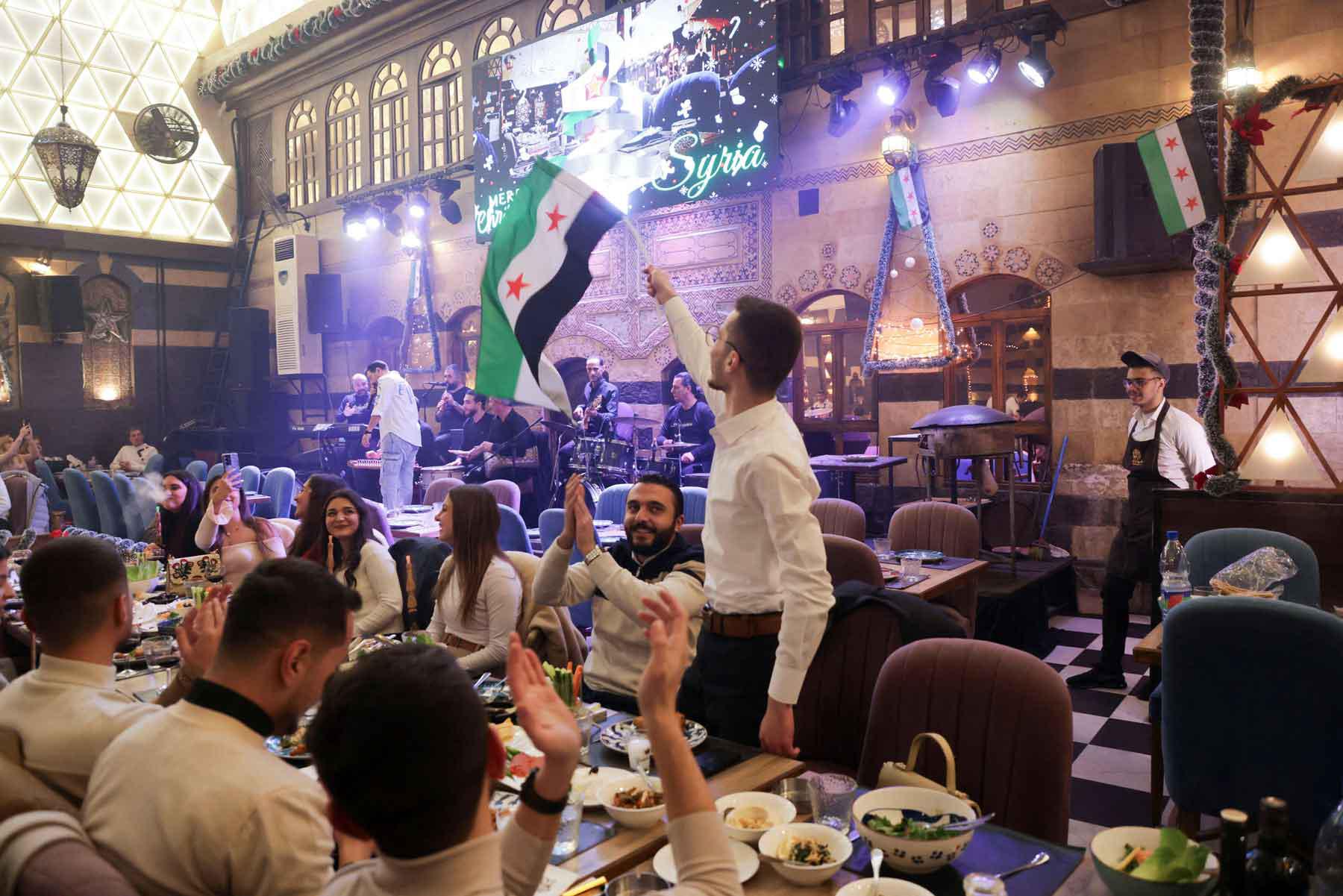 People gather on Christmas day at a restaurant in Damascus.