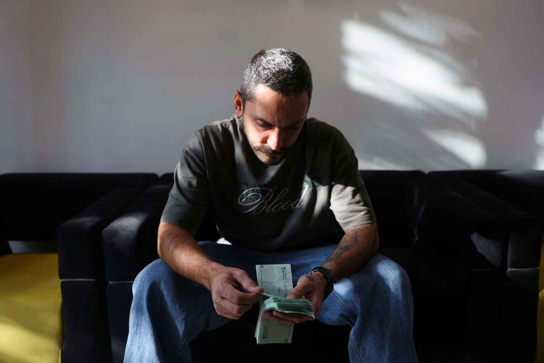 A currency dealer holds Iranian rial bills in Tehran.