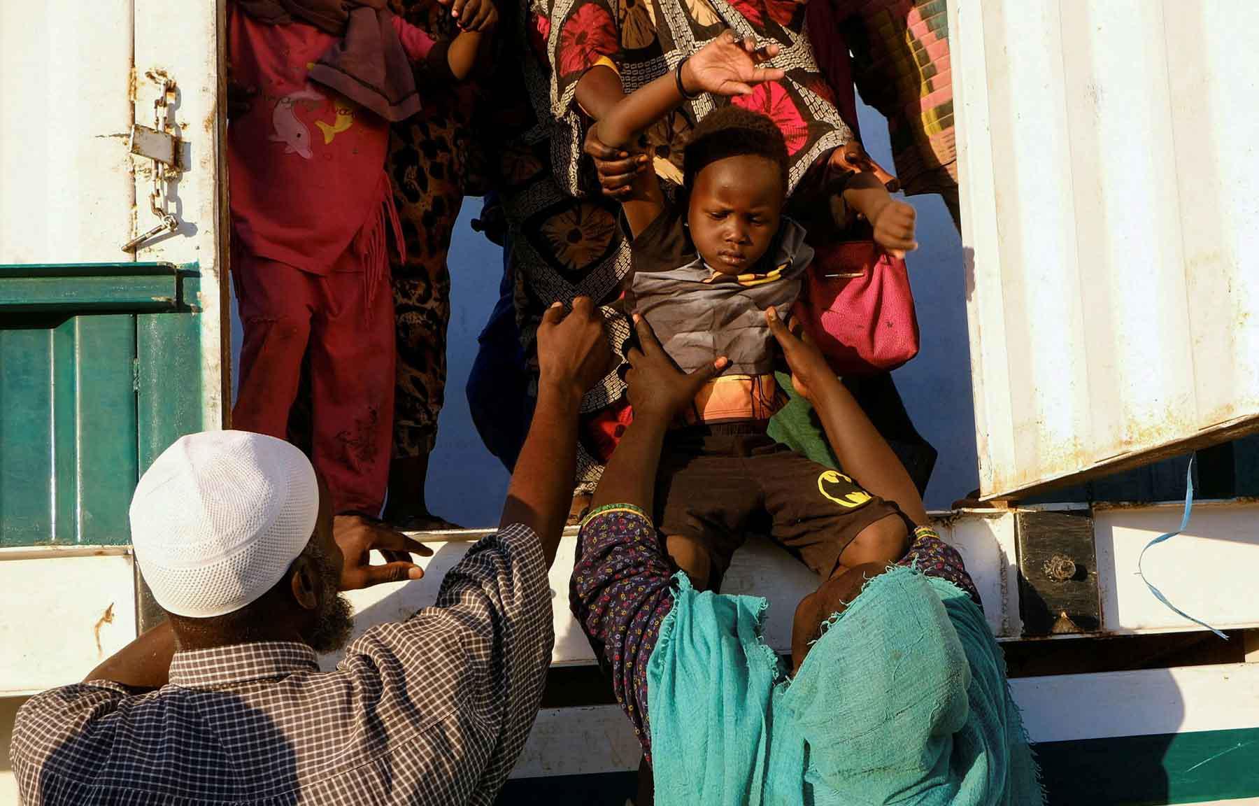 A displaced boy from al-Fashir gets down from a truck, at a displacement camp in Al-Dabba, Sudan, November 19, 2025. 