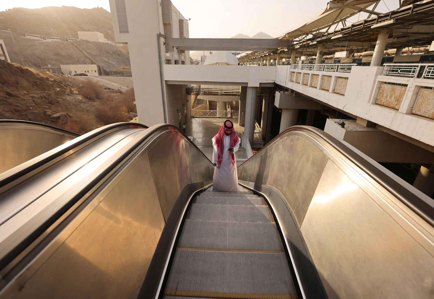 A Saudi man rides an escalator at a train station in Mecca, Saudi Arabia. 