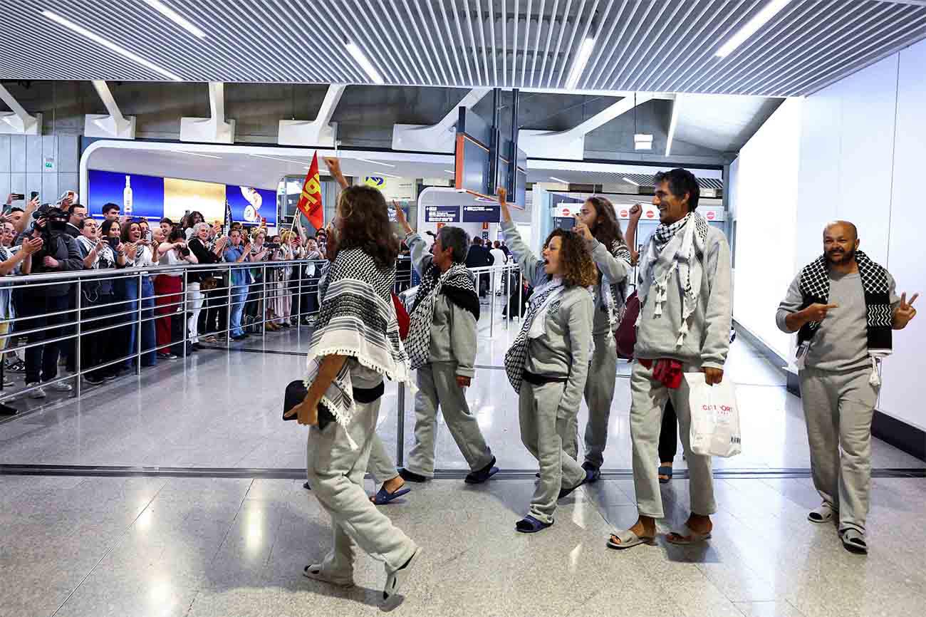 French activists from the Gaza-bound Global Sumud Flotilla gesture upon arrival at Charles de Gaulle Airport near Paris on May 22