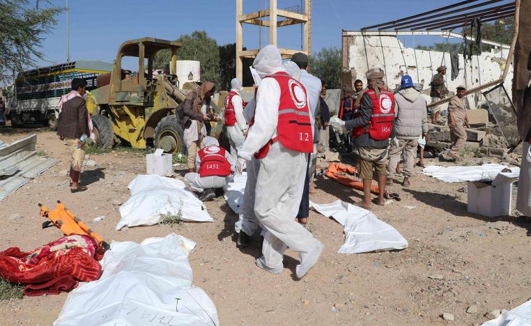 Yemeni rescuers transport the bodies of victims pulled from the rubble of a building hit in US strikes in Saada