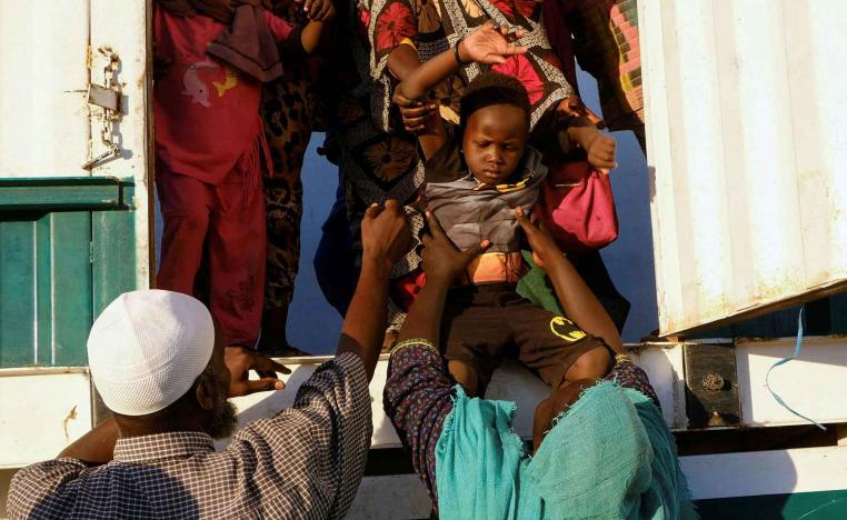 A displaced boy from al-Fashir gets down from a truck, at a displacement camp in Al-Dabba, Sudan, November 19, 2025. 
